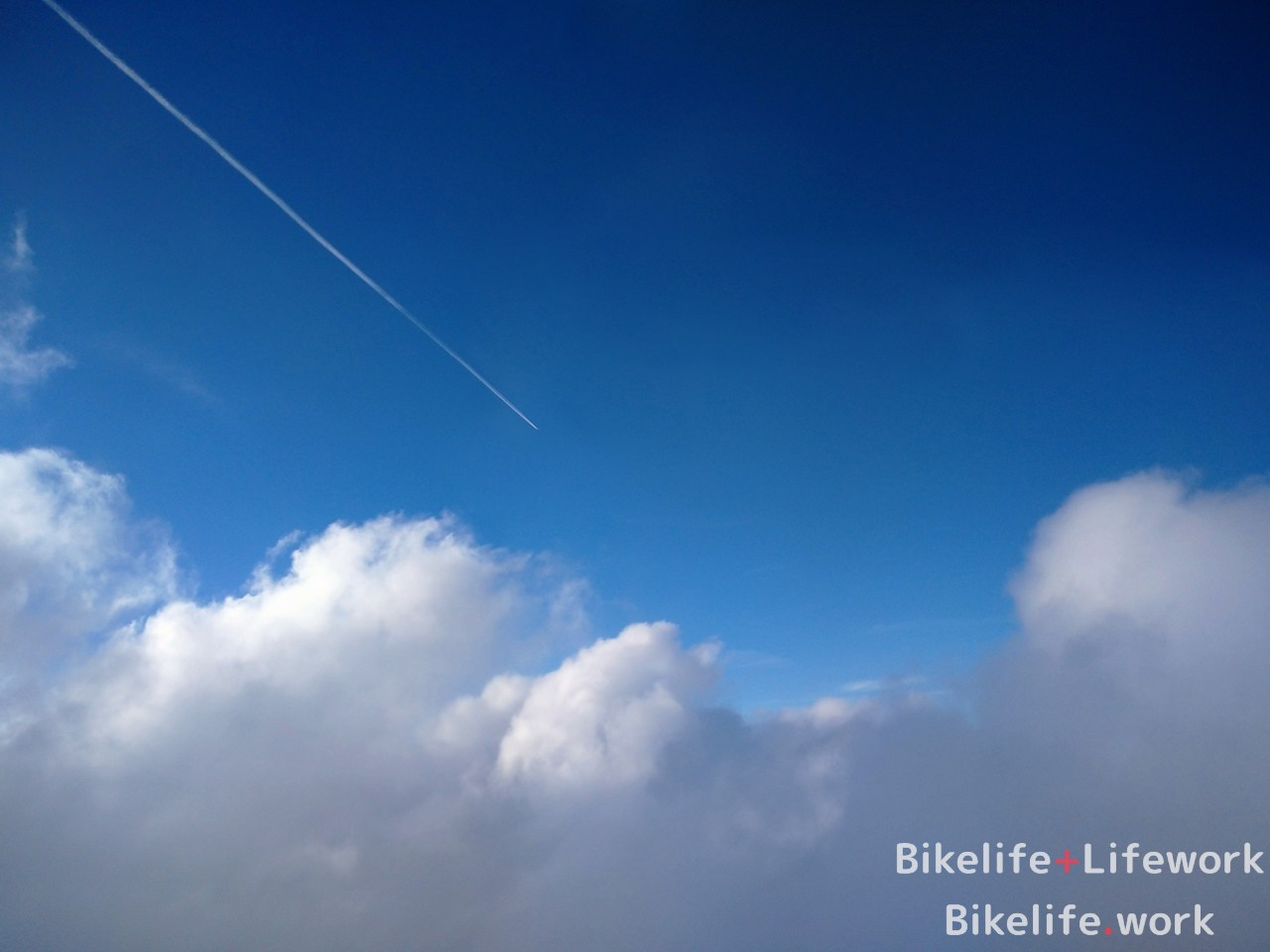 雲の上の青空と飛行機雲